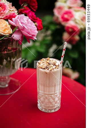 Chocolate milkshake with a straw on the red table 69933449