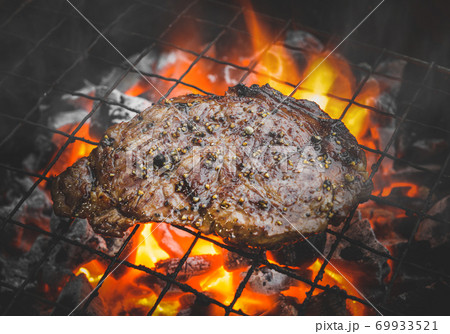 Pepper beef steak grilling with flame. 69933521