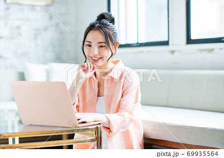 リビングでパソコンを使う若い女性 69935564