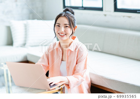 リビングでパソコンを使う若い女性 69935565