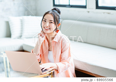 リビングでパソコンを使う若い女性 69935566