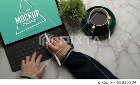 Female hands typing on mock up digital tablet on marble desk Female hands typing on mock up digital tablet on marble desk 69935804