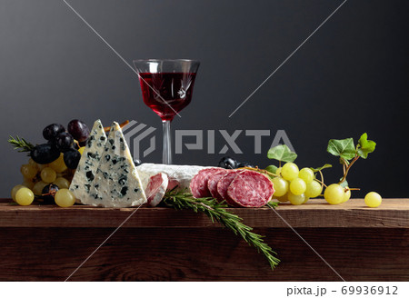 Red wine and snacks on an old wooden table. Red wine and snacks on an old wooden table. 69936912