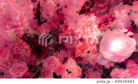 Selective focus on pink and red plastic flower with lamp light. Fake flowers. Bouquet of plastic flower for decor in wedding event or valentines day. Flower for Love and romantic abstract background. 69936983