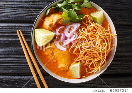 Coconut curry soup with chicken, fried noodles and spices. Thai style. horizontal top view 69937014