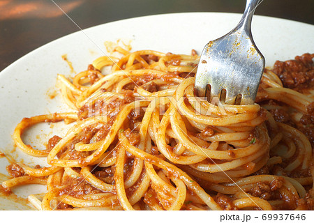フォークで食べかけのテーブルの上のボロネーズソースのスパゲッティ 69937646