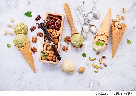 Pistachio and vanila ice cream in cones  with mixed nut setup on white stone background . Summer and Sweet menu concept. 69937897