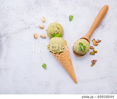 Pistachio ice cream in cones  with pistachio nuts setup on white 69938044