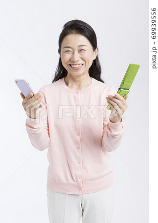 スマホとガラケーを持つ女性 69939556