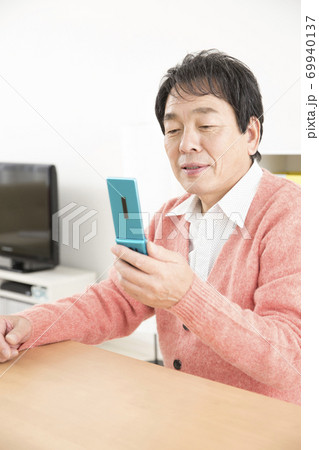 携帯メールを見る男性 携帯メールを見る男性 69940137