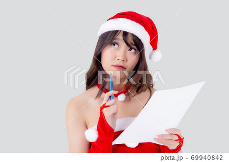 Beautiful portrait young asian woman thinking and writing notepad in xmas day isolated. 69940842