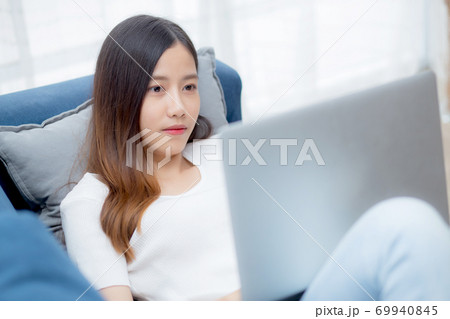 Young asian business woman smile and work from home with laptop computer. 69940845
