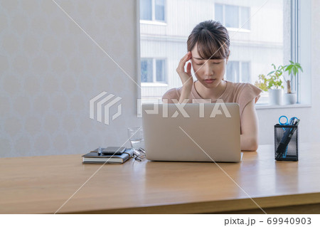長期化するテレワークで疲弊する若い女性 【頭を抱える】 69940903