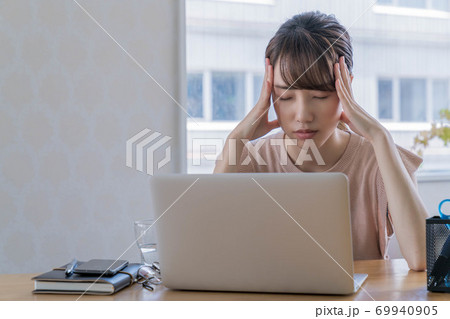 長期化するテレワークで疲弊する若い女性 【頭を抱える】 69940905