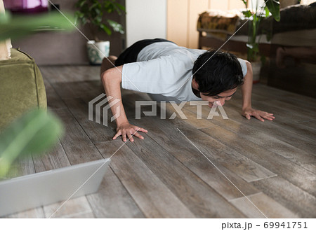 部屋で筋トレをする男性 69941751