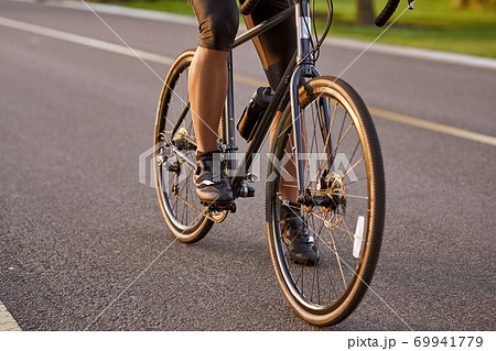 Riding. Cropped shot of a man cycling outdoors. Focus on male legs Riding. Cropped shot of a man cycling outdoors. Focus on male legs 69941779