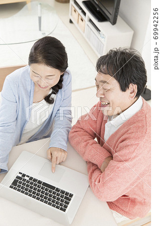 ノートパソコンをするミドル夫婦 69942256