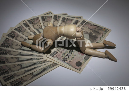 お金と落ち込むデッサン人形 69942428