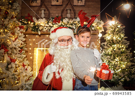 Santa gives presents to children in a room at Christmas 69943585