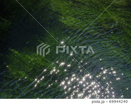 太陽をキラキラと反射している水面の写真素材