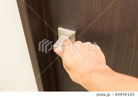 ドアノブを握る男性 69946193