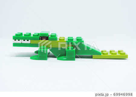 The shape of a green crocodile is made from colorful plastic toy bricks. The shape of a green crocodile is made from colorful plastic toy bricks. 69946998