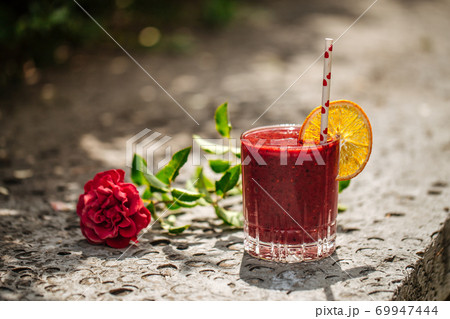 Red berry smoothie in glass with flower Red berry smoothie in glass with flower 69947444