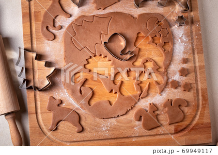 Cutting out shapes from dough for gingerbread Christmas cookies 69949117