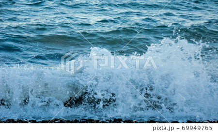 The waves breaking on a stony beach. Mediterranean sea waves crashing on the rocks at the beach 69949765