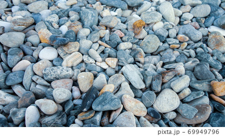 Stony beach on a sunny day. Background of different pebbles from above on the beach Stony beach on a sunny day. Background of different pebbles from above on the beach 69949796