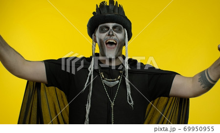 Happy creepy man with skeleton makeup celebrating win, emotionally rejoicing in victory success Happy creepy man with skeleton makeup celebrating win, emotionally rejoicing in victory success 69950955