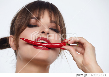 beautiful girl posing with red chili peppers. Studio, White background beautiful girl posing with red chili peppers. Studio, White background 69952654