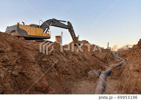 Excavator dig the trenches at a construction site. Excavator dig the trenches at a construction site. 69953196