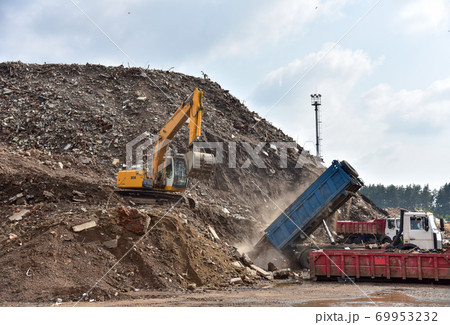 Excavator dig construction waste at landfill. Excavator dig construction waste at landfill. 69953232
