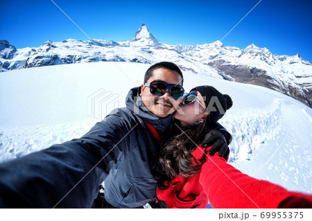Young Couple Tourists selfie near view of snow mountain Matterhorn, Zermatt, Switzerland 69955375