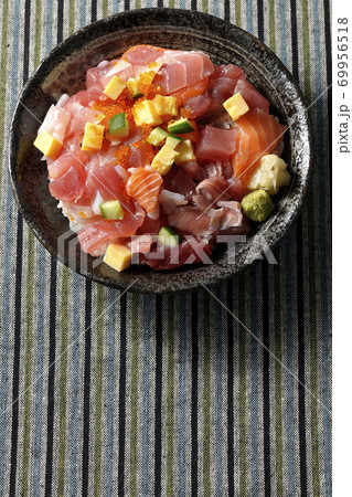 和柄の布の上に置かれた鮪やサーモンなどが入った海鮮丼（俯瞰） 69956518