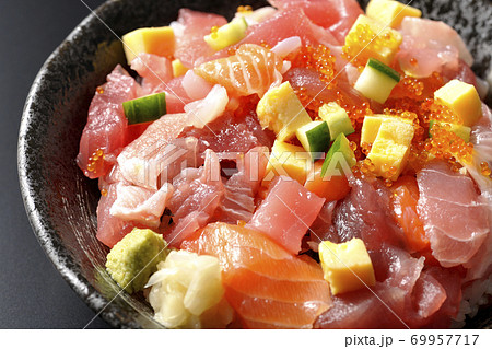 鮪やサーモン、きゅうりやとびこなどが入った海鮮丼（黒背景） 69957717