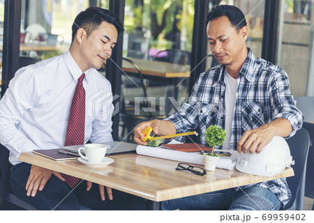 Contractor construction engineer meeting together on architect table at construction site 69959402