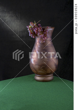 Large vase with a bunch of grapes on the table Large vase with a bunch of grapes on the table 69959924