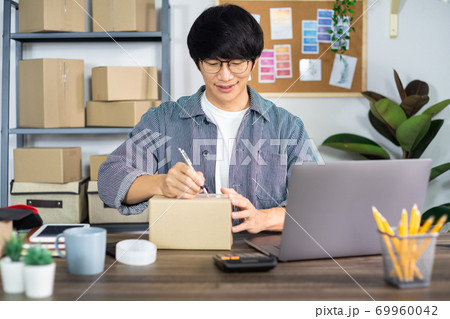 Asian man entrepreneur startup small business entrepreneur SME freelance man working with box to online marketing packaging and delivery scene at home office, onlinebusiness seller concept. Asian man entrepreneur startup small business entrepreneur SME freelance man working with box to online marketing packaging and delivery scene at home office, onlinebusiness seller concept. 69960042