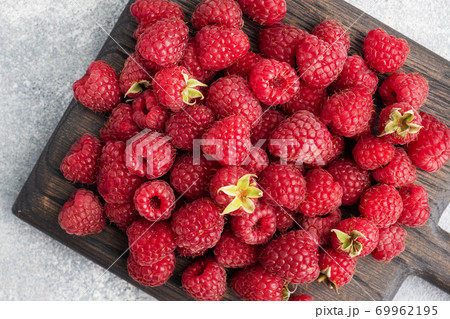 A pile of fresh juicy raspberries on a wooden Board, copy space. 69962195