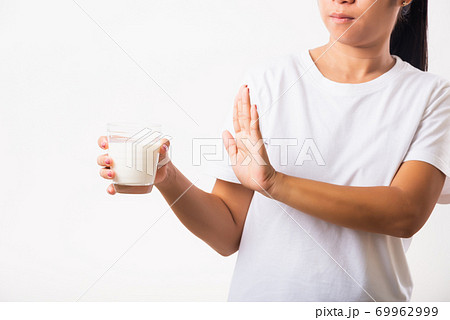 Woman raises a hand to stop sign use hand holding glass milk she is bad stomach ache has bad lactose Woman raises a hand to stop sign use hand holding glass milk she is bad stomach ache has bad lactose 69962999