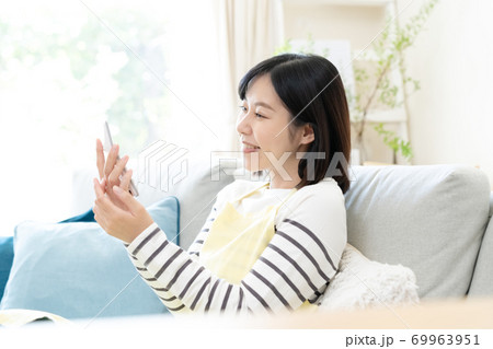 電卓を見るミドル女性【笑顔】 69963951