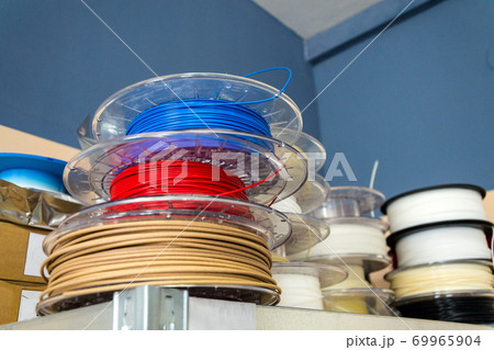 Stacks of 3d printing filament in different colors lying on metal shelf Stacks of 3d printing filament in different colors lying on metal shelf 69965904