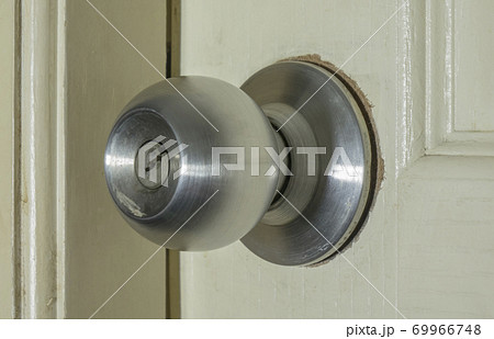 Broken door knob on white wooden door 69966748