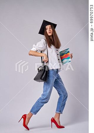 Beautiful european graduate girl is carrying a copybook. Beautiful european graduate girl is carrying a copybook. 69970753