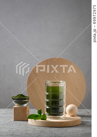 Chlorella healthy drink in glass on podium. Chlorella healthy drink in glass on podium. 69972975