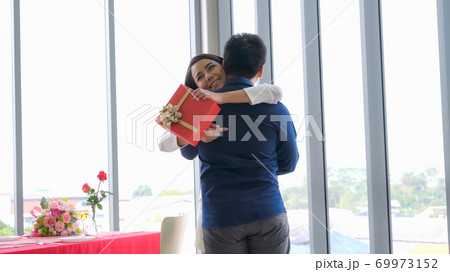 Romantic couple giving gift to lover at restaurant 69973152