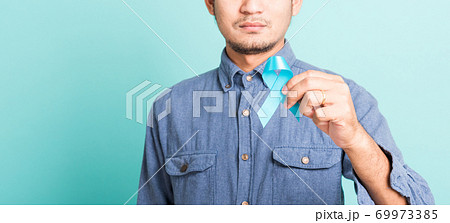 handsome man posing he holding light blue ribbon for supporting people living 69973385