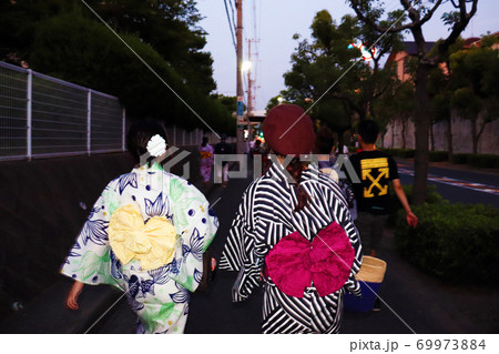 花火大会に出かける浴衣の女の子二人の後ろ姿の写真素材